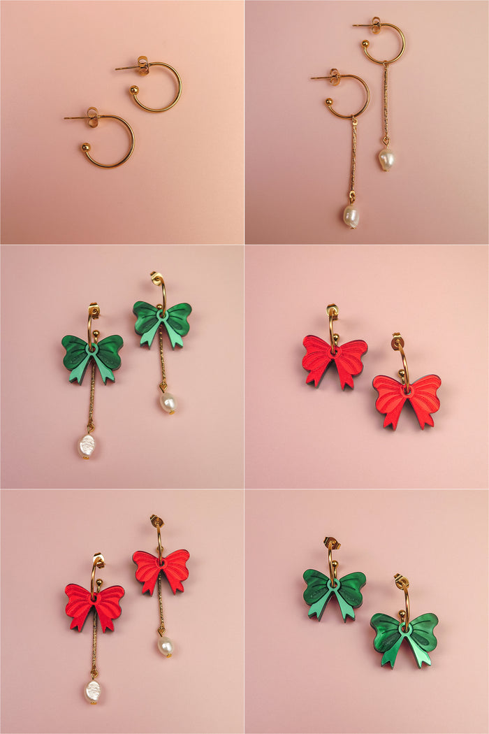 A grid of six pairs of interchangeable dangle earrings on a pink background, featuring gold-plated c-hoops, gold hoops with freshwater pearls, green and red bow charms, and playful combinations of bows and pearls.