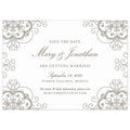 White horizontal save the date with circle and scroll pattern in pewter in all the corners of the card. Block and script font in pewter centered on the page.