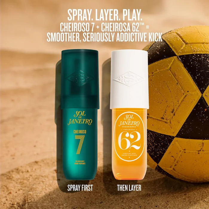 Two bottles of Sol Janeiro Cheiroso 7 and Cheiroso 62 perfume spray standing side by side on a sandy surface, with a yellow and black soccer ball in the background. White text at the top reads 'SPRAY.