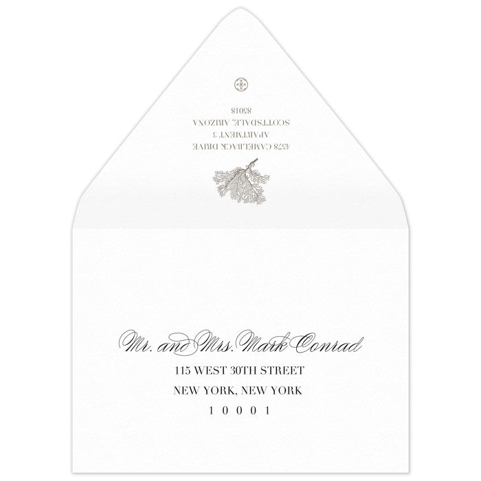 White envelope with a coral motif and block return address on the flap. Scrip and block address on the front.