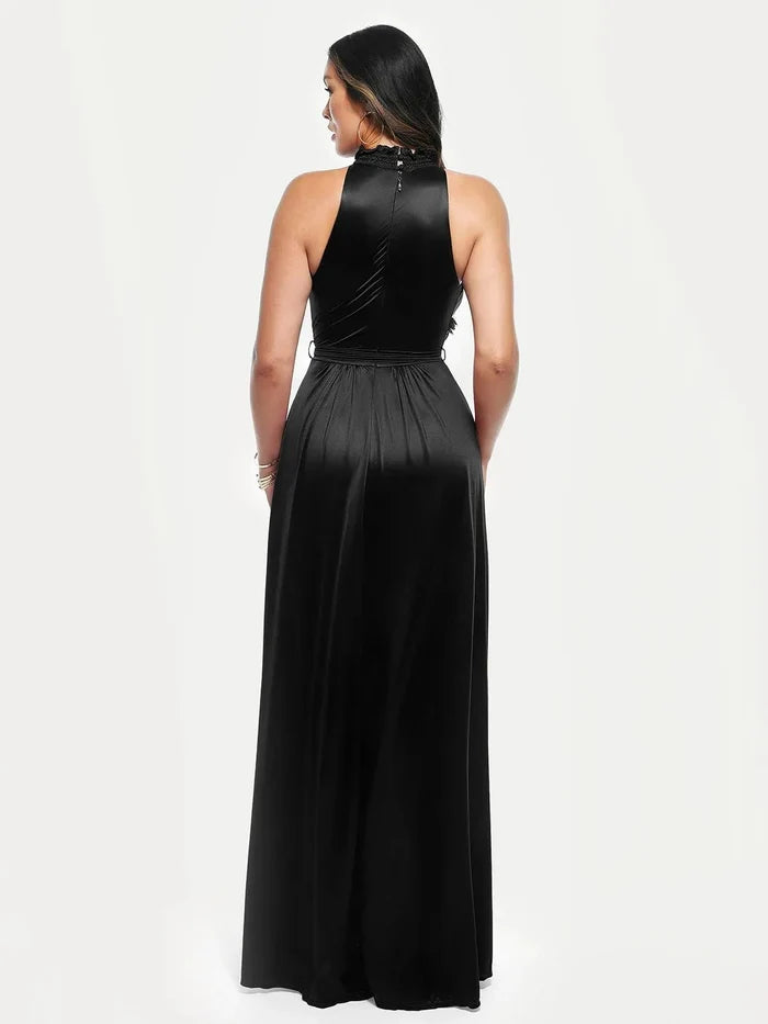 Woman wearing a black draped high neck floral-print maxi dress, showcasing its A-line skirt and high slit.