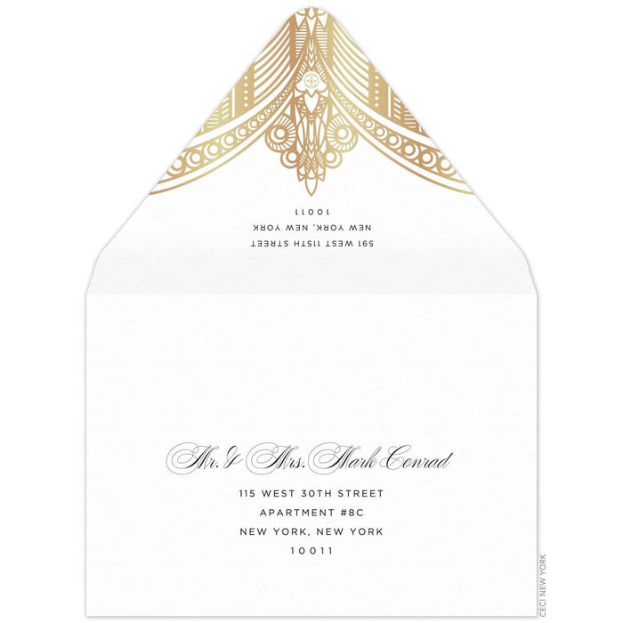 White envelope, gold deco pattern on the tip of the envelope flap. Black san serif return address. Black block and script mailing address on the front of the envelope.