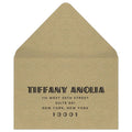Gold reply envelope with black deco font centered on the front of the envelope.