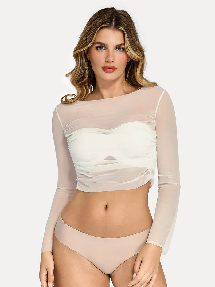 White ruched sheer mesh long sleeve crop top with off-shoulder neckline, showing slimming cropped fit.