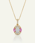 Gold necklace with a pendant featuring pink gemstones and diamonds on a white background