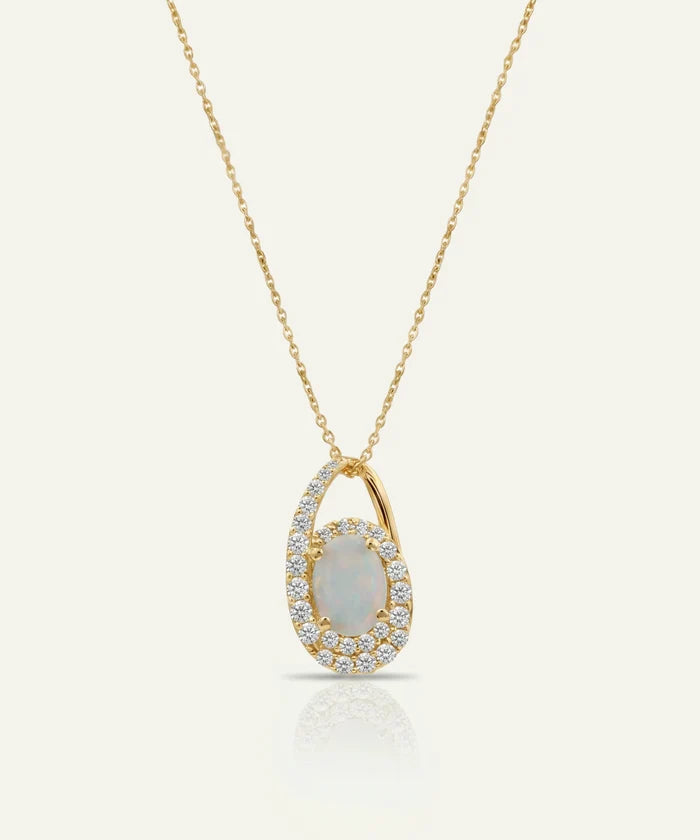 Gold necklace with a pendant featuring an opal stone on a light gray background
