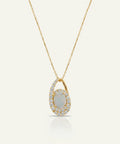 Gold necklace with a pendant featuring an opal stone on a light gray background