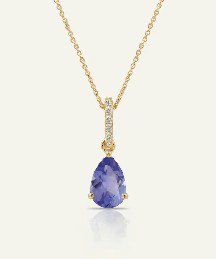 Gold necklace with a purple teardrop pendant on a white background