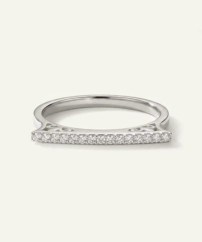 Silver ring with small diamonds on a light gray background