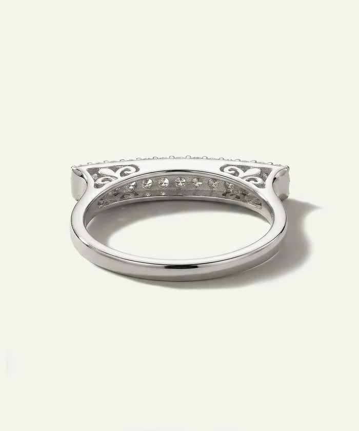 Silver ring with intricate design on a white background