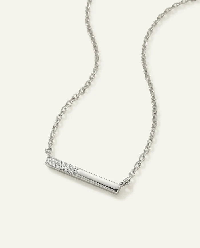 Silver necklace with a bar pendant on a light gray background