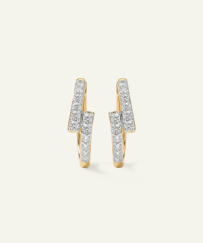 Pair of gold earrings with diamond accents on a light gray background