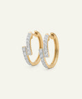 Gold hoop earrings with diamond accents on a light gray background