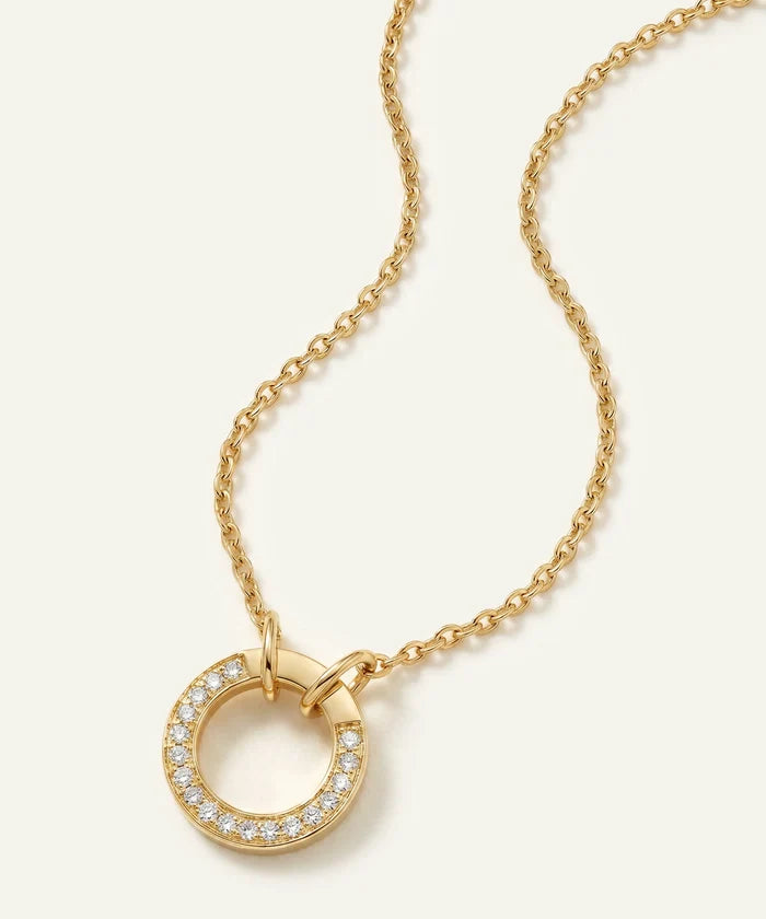 Gold necklace with a circular pendant on a white background