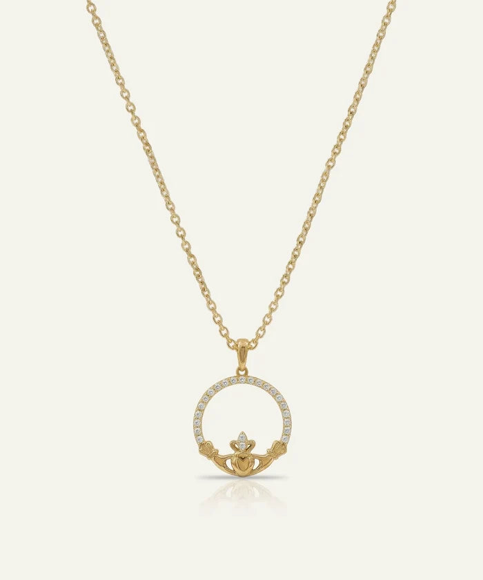 Gold necklace with a claddagh pendant on a white background