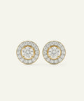 Pair of gold and diamond earrings on a light beige background