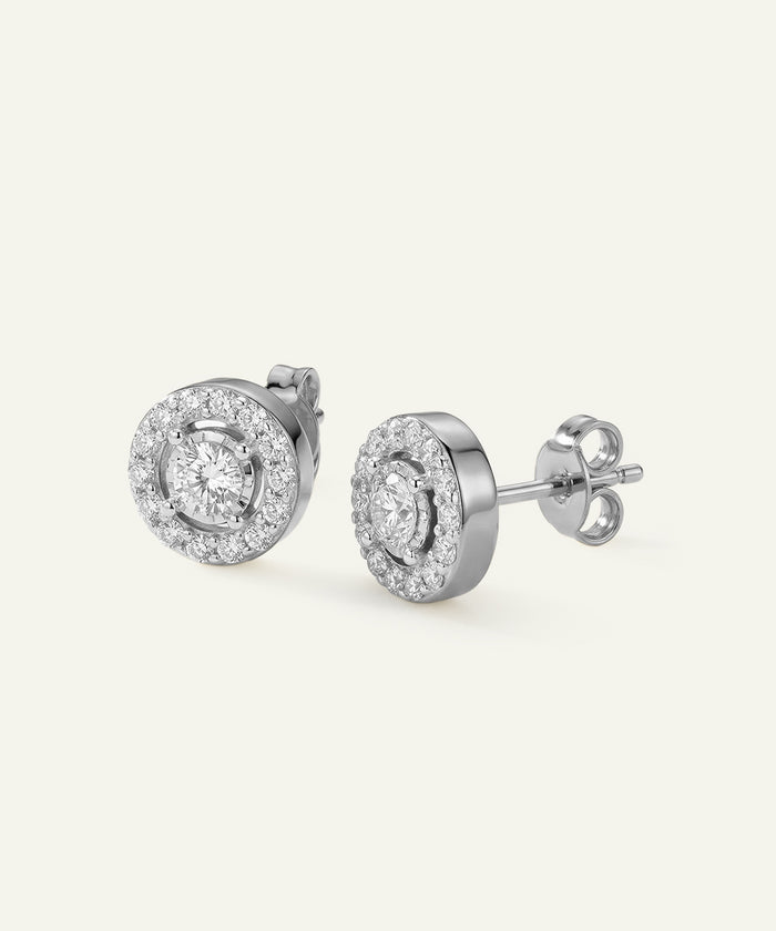 Pair of silver earrings with clear gemstones on a white background