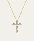 Gold necklace with a cross pendant on a light gray background