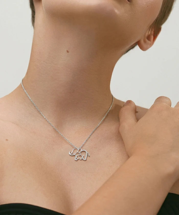 Person wearing a silver necklace with a bear pendant on a neutral background