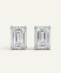 Pair of emerald-cut diamond stud earrings on a white background