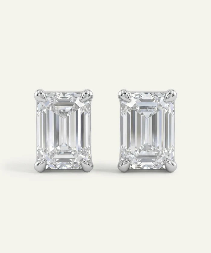 Pair of emerald-cut diamond stud earrings on a white background