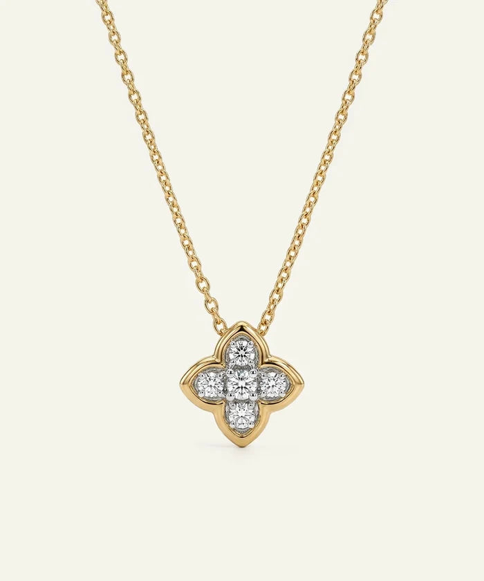 Gold necklace with a diamond quatrefoil pendant on a white background