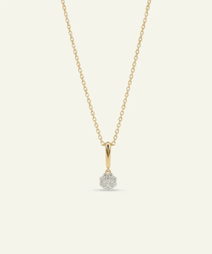 Gold necklace with a small diamond pendant on a light gray background