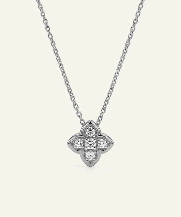 Silver necklace with a clover-shaped pendant on a white background