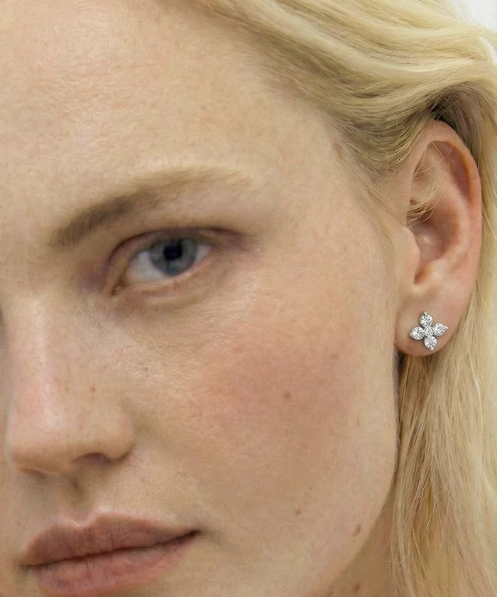 Close-up of a woman wearing a diamond earring.