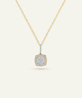 Gold necklace with a square pendant on a light beige background