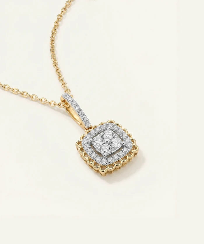 Gold necklace with a diamond pendant on a light beige background