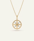 Gold necklace with a star-shaped pendant on a light beige background