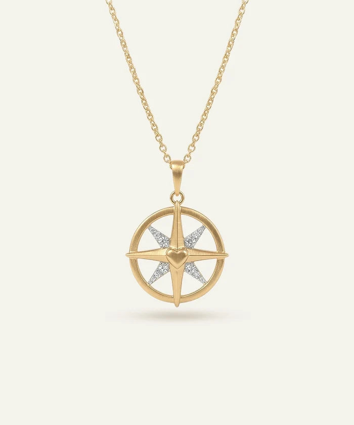 Gold necklace with a star-shaped pendant on a light beige background
