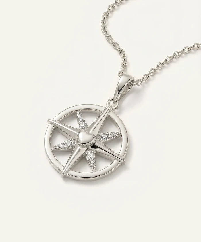 Silver necklace with a star-shaped pendant on a light gray background
