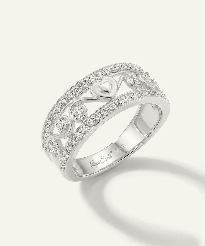 Silver ring with intricate design and diamonds on a white background