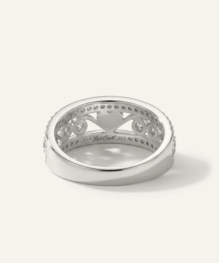 Silver ring with intricate design on a white background