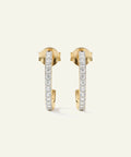 Gold hoop earrings with embedded diamonds on a light beige background