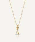 Gold necklace with a delicate pendant on a light beige background