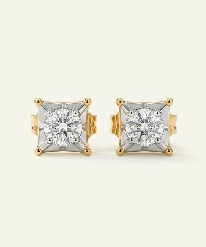 Pair of gold and diamond stud earrings on a light beige background