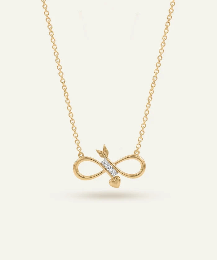 Gold infinity necklace with arrow pendant on a light beige background
