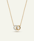 Gold necklace with interlocking rings pendant on a light beige background