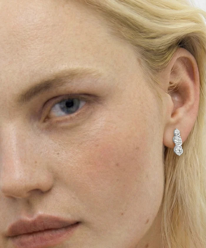 Close-up of a woman wearing a diamond earring.