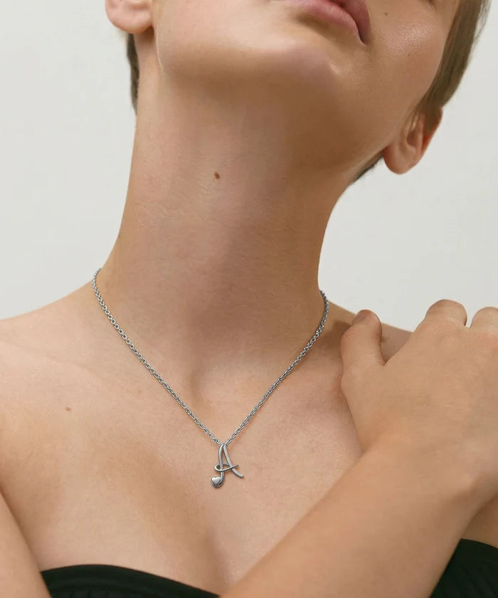 Necklace with a pendant worn by a person on a neutral background