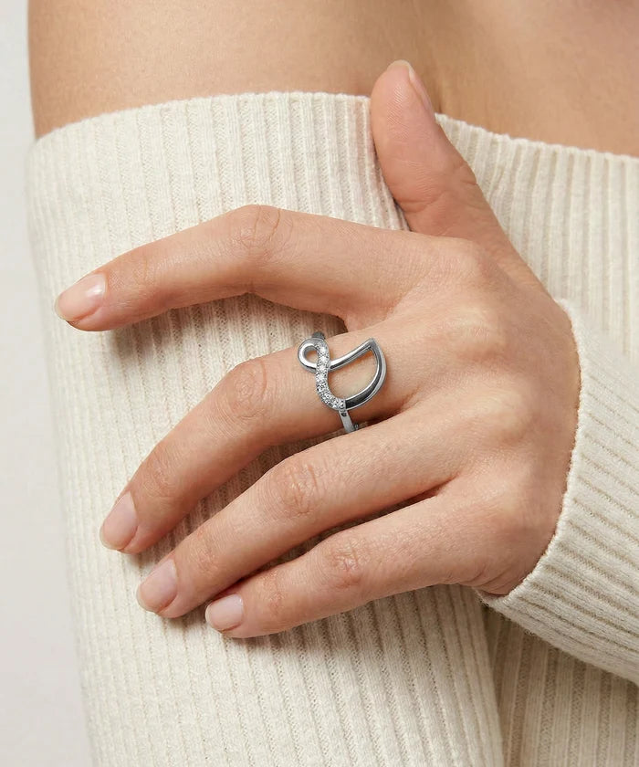 Hand wearing a silver ring with a white background