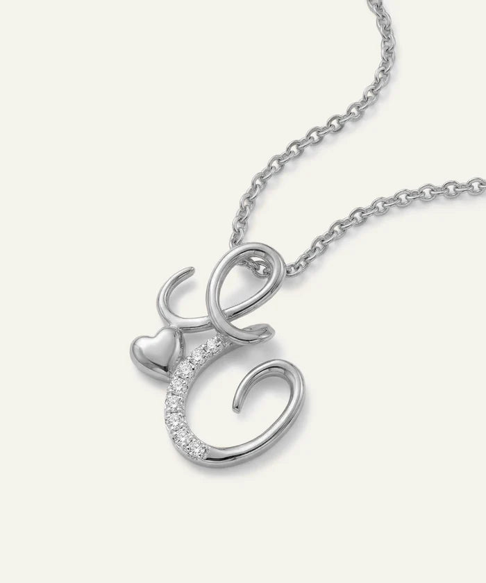 Silver necklace with a heart and 'C' pendant on a white background