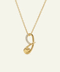 Gold necklace with a unique pendant on a light beige background