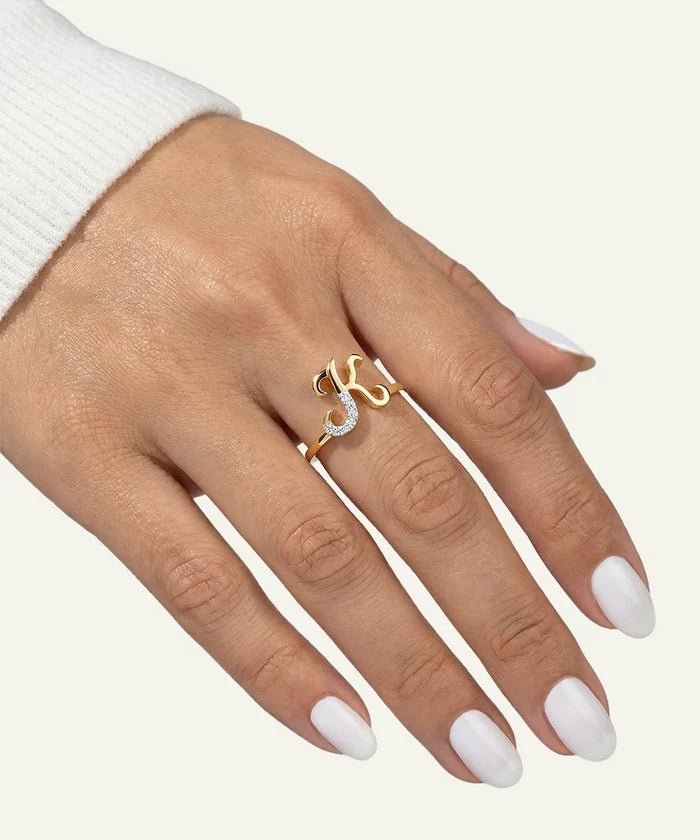 Hand wearing a gold ring with a diamond on a white background