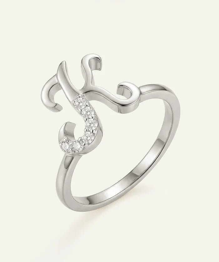 Silver ring with a curved design and small gemstones on a white background