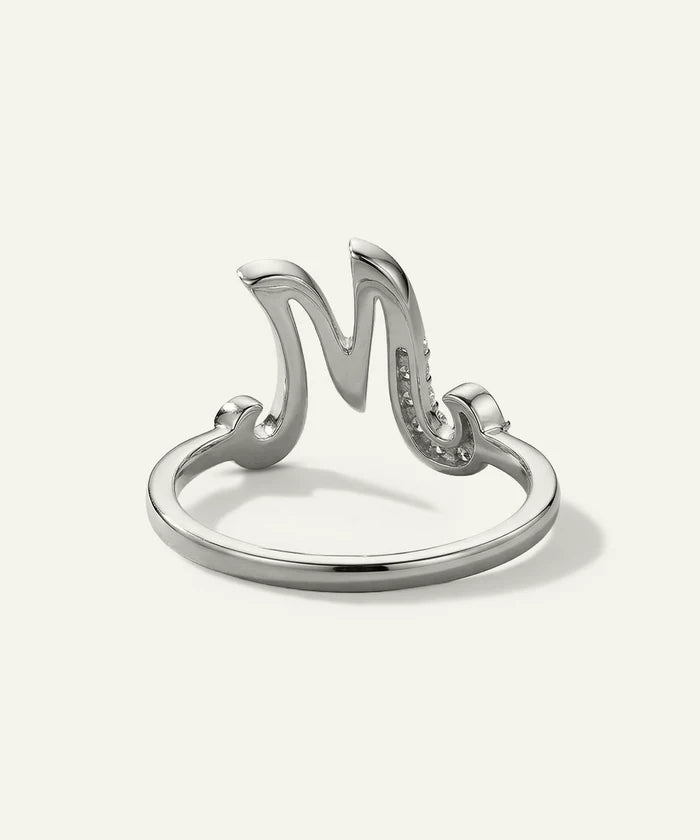 Silver ring with a stylized 'M' design on a white background