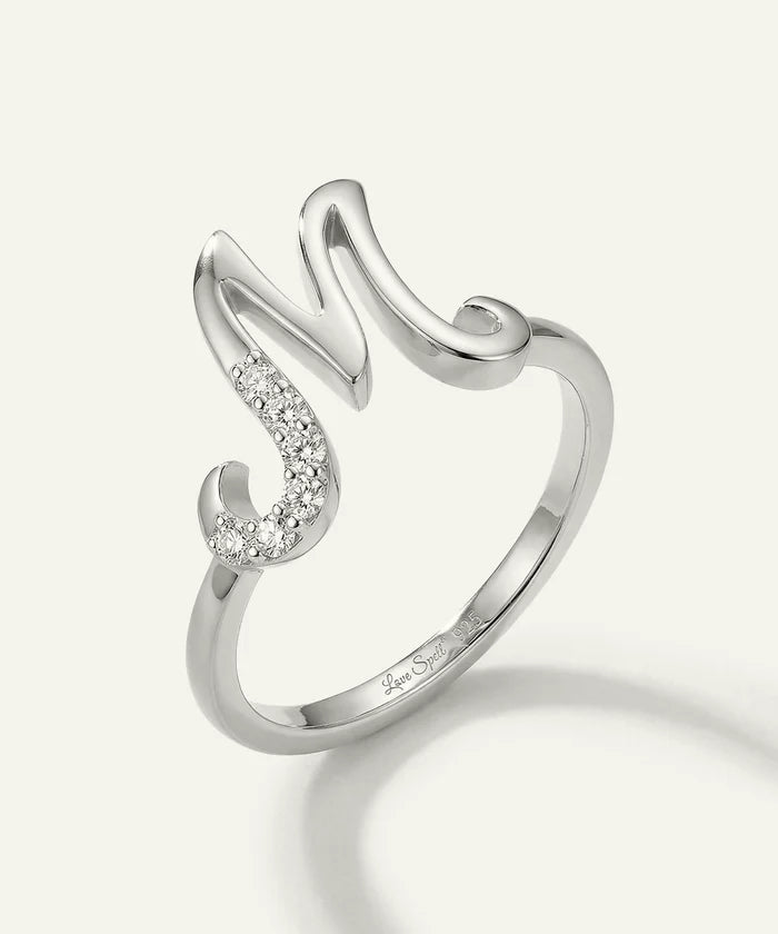 Silver ring with diamond accents on a light gray background
